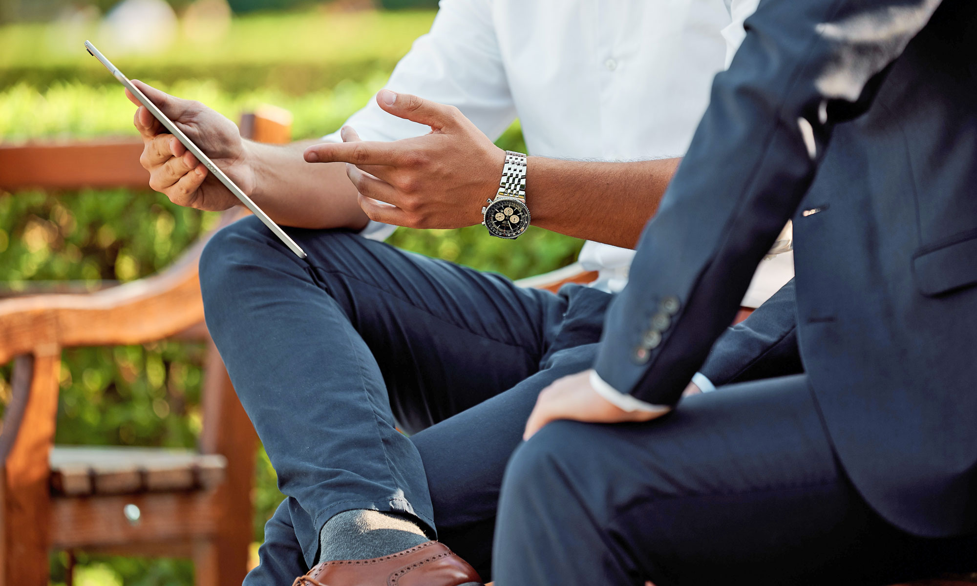 2 people looking at an iPad in the park